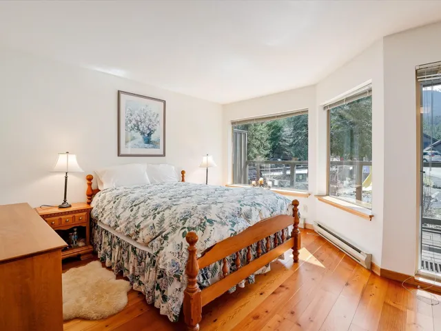 Bedroom with light wood-style flooring, a baseboard radiator, and baseboards