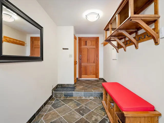 Mudroom featuring stone finish floor and baseboards