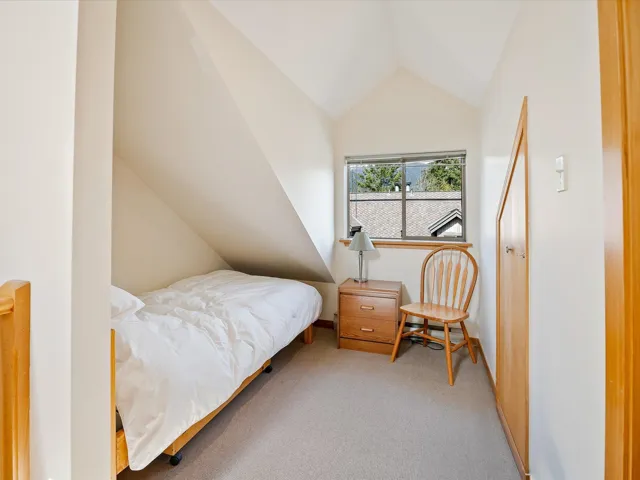 Bedroom featuring baseboards, carpet flooring, and vaulted ceiling