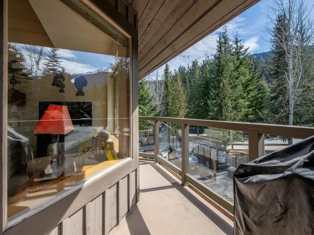 Balcony featuring a grill, a view of trees, and a mountain view