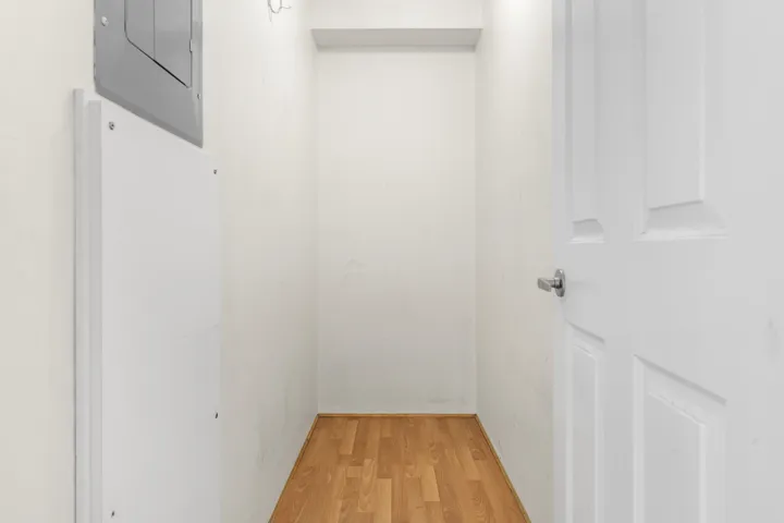 Hall with light wood-style flooring and electric panel
