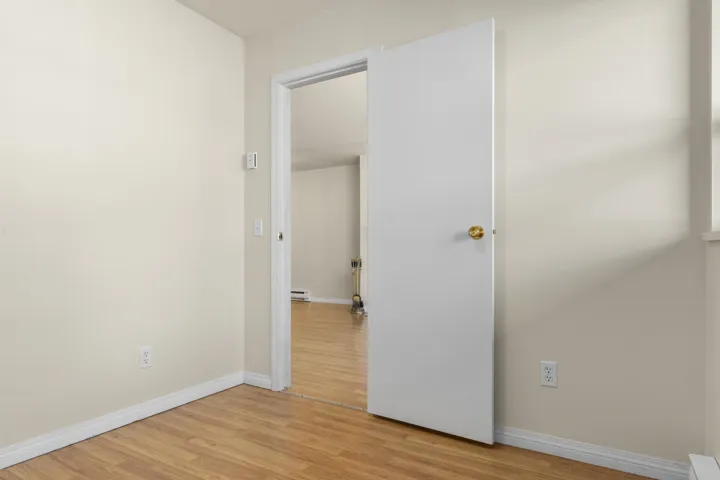 Spare room featuring a baseboard heating unit, light wood-type flooring, and baseboards
