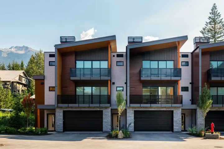 View of building exterior with driveway, a mountain view, and an attached garage