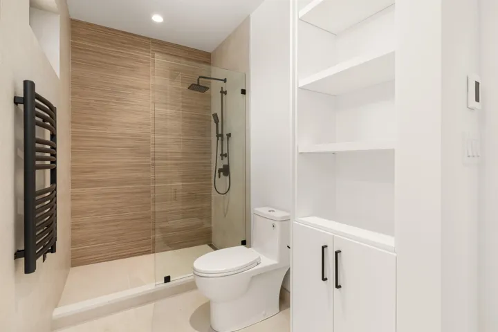 Bathroom featuring a walk in shower, radiator heating unit, light tile patterned floors, recessed lighting, and a towel warming rack
