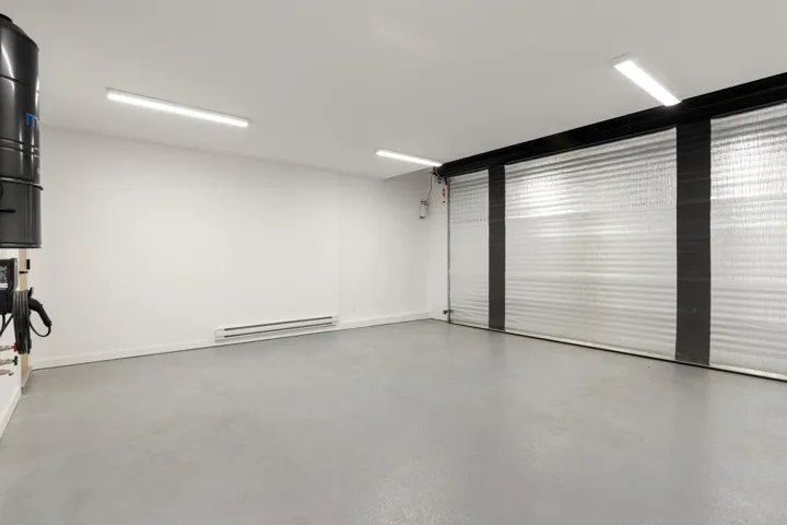 Garage featuring a baseboard heating unit and a central vacuum unit