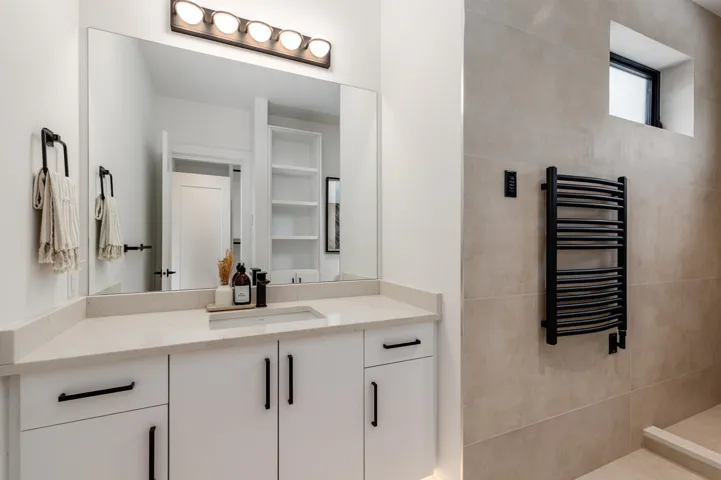 Full bath featuring vanity, radiator heating unit, and a towel warming rack