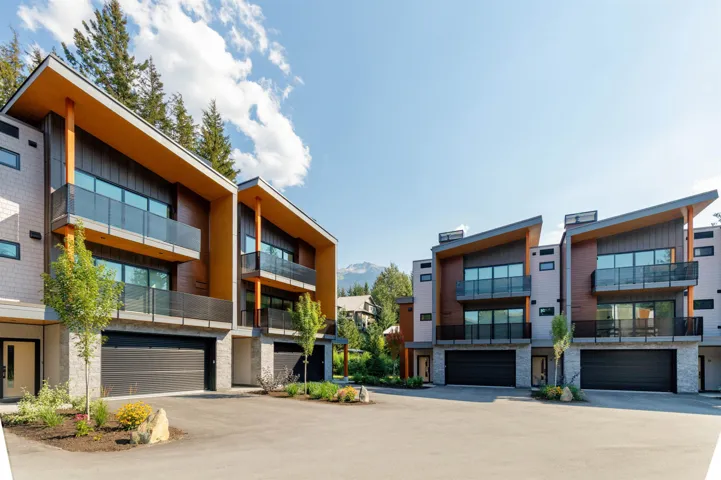 View of apartment building / complex featuring driveway, a garage, and a mountain view
