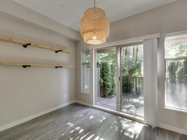 Unfurnished dining area featuring wood finished floors and a chandelier
