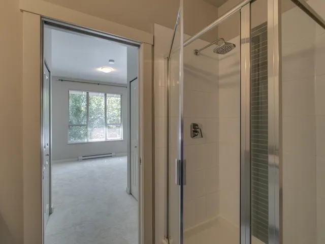 Full bath with a stall shower and a baseboard heating unit