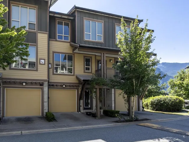 View of front of house featuring board and batten siding, an attached garage, driveway, and a mountain view