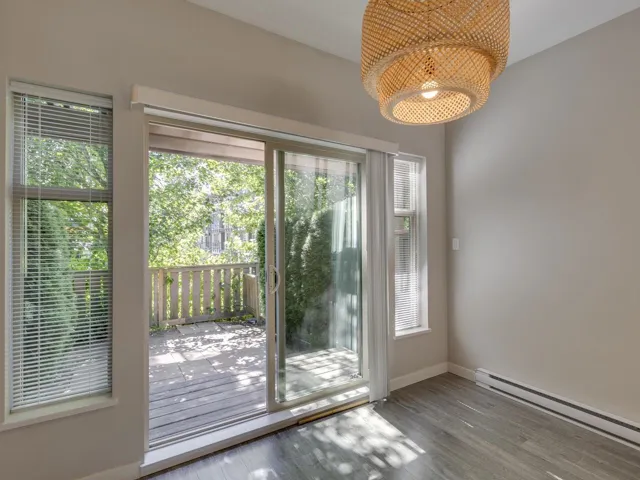 Doorway to outside with baseboard heating, a chandelier, and wood finished floors