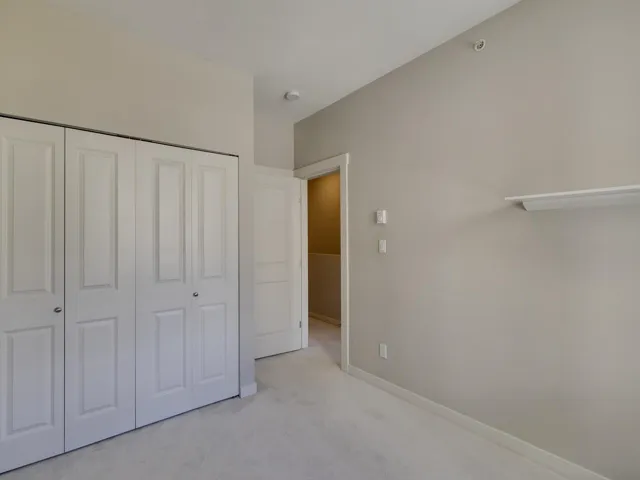 Unfurnished bedroom with light carpet and a closet