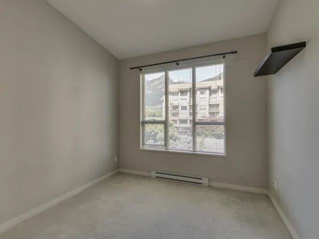 Spare room featuring light carpet and baseboard heating