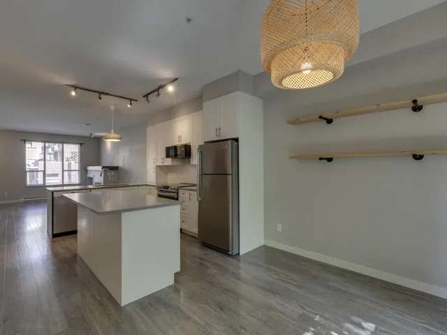 Kitchen featuring a peninsula, appliances with stainless steel finishes, dark wood finished floors, and white cabinets