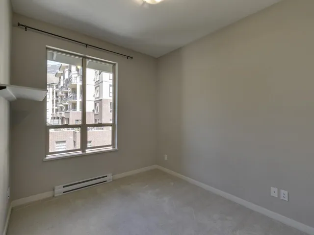 Spare room featuring baseboard heating and carpet