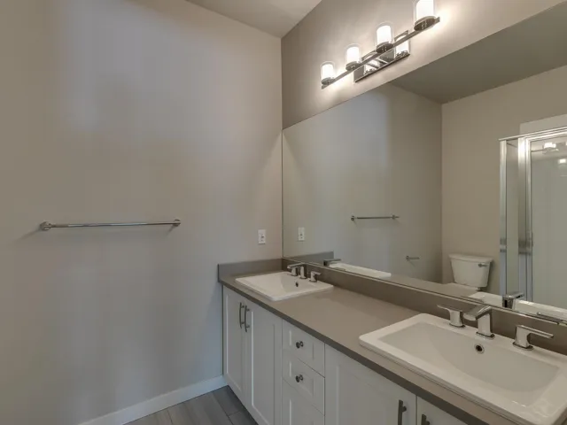 Full bathroom with double vanity and a shower with door