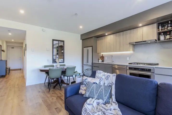 Kitchen featuring modern cabinets, open floor plan, stainless steel appliances, recessed lighting, and dual tone cabinetry