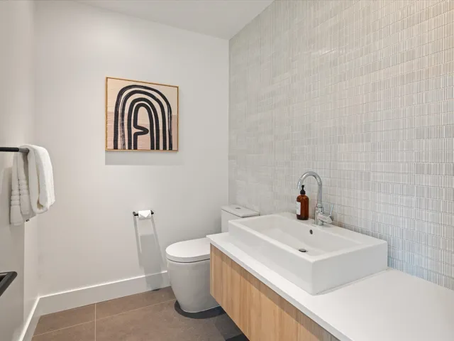 Bathroom featuring dark tile patterned flooring, vanity, and tile walls