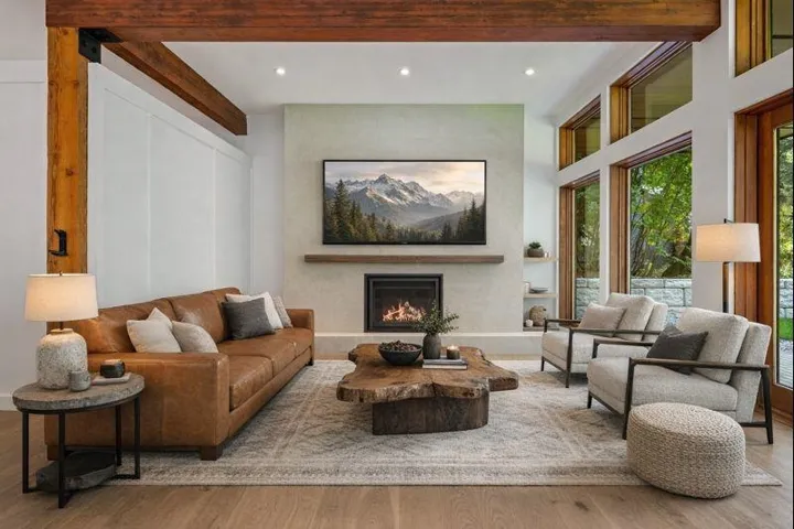 Living area with a warm lit fireplace, recessed lighting, wood finished floors, beamed ceiling, and a high ceiling