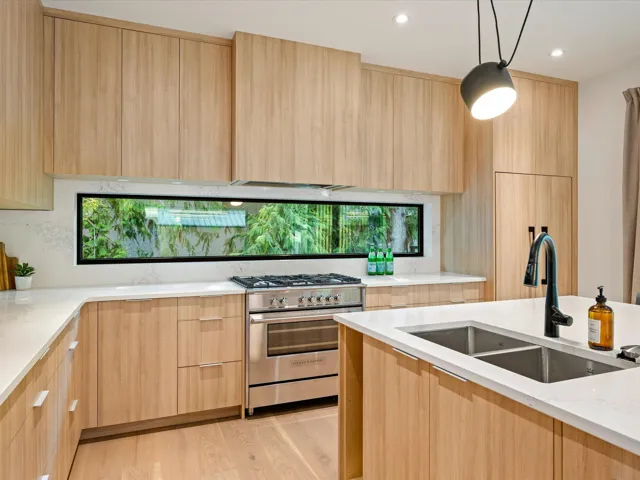Kitchen with light brown cabinets, modern cabinets, light stone counters, high end stove, and recessed lighting