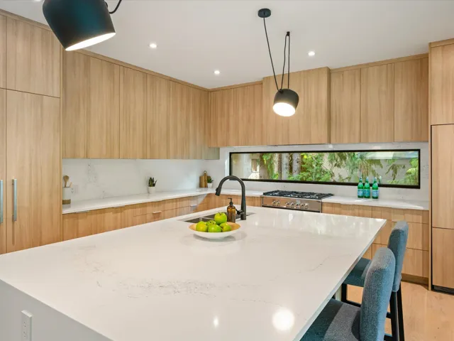Kitchen featuring light stone counters, hanging light fixtures, modern cabinets, light brown cabinets, and recessed lighting