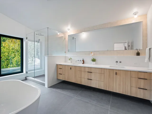 Full bathroom featuring backsplash, a soaking tub, double vanity, a shower stall, and dark tile patterned floors