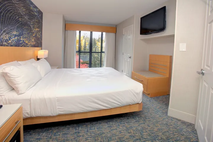 Bedroom featuring dark colored carpet and baseboards