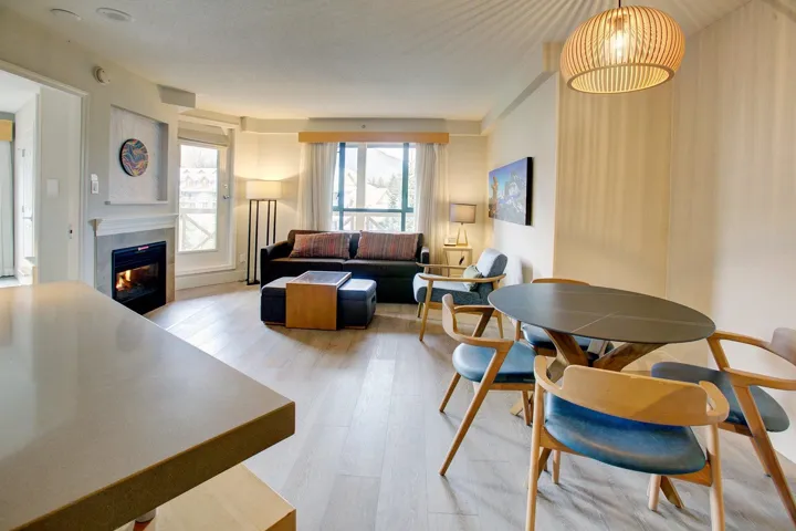 Living room with light wood finished floors and a glass covered fireplace