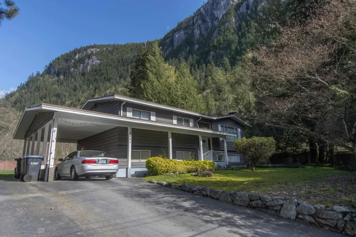 View of front of property with driveway, a front yard, an attached carport, and a mountain view