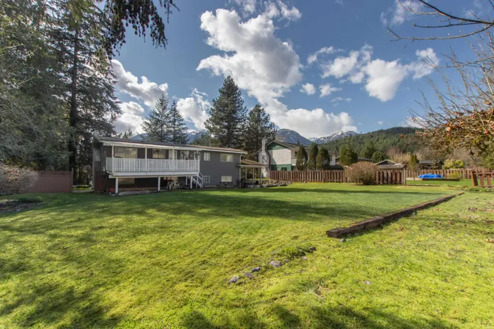 View of yard with stairway, a sunroom, fence, and a mountain view