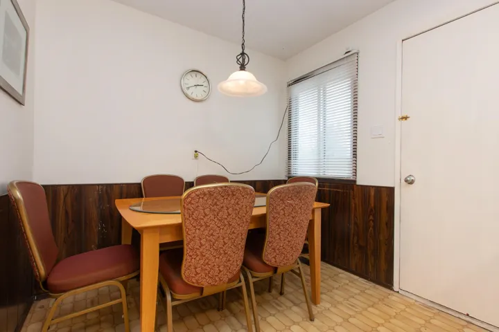 Dining space featuring light floors and a wainscoted wall