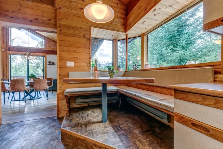Dining area featuring a chandelier, plenty of natural light, and wood walls