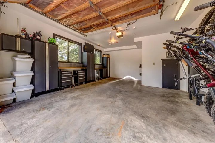 Unfurnished living room featuring unfinished concrete floors and a garage