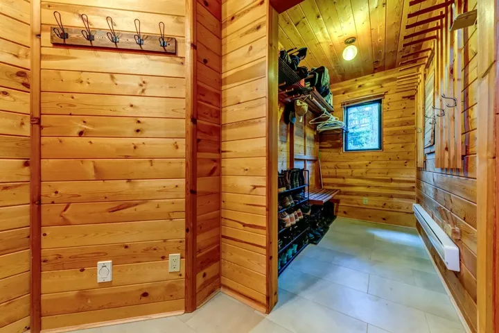Bathroom with baseboard heating, wood walls, wooden ceiling, and a sauna / steam room
