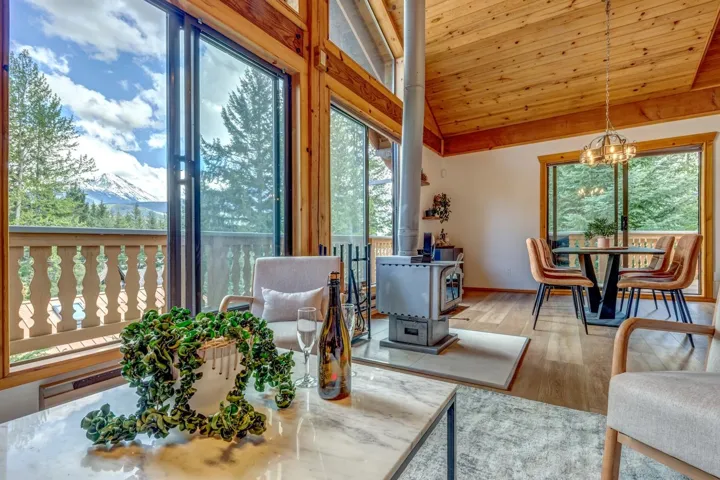 Sunroom / solarium featuring a wood stove, lofted ceiling, and a chandelier