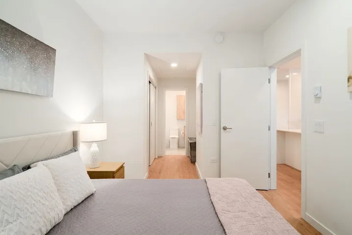 Bedroom with light wood-style flooring, connected bathroom, and recessed lighting