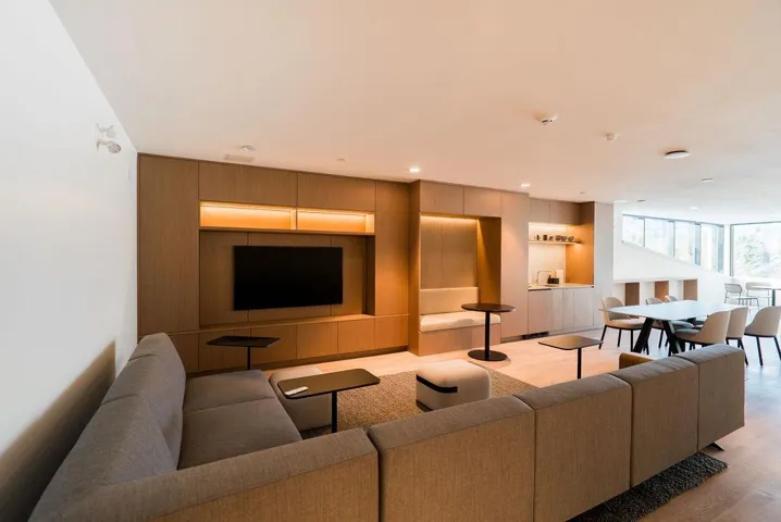Living room style room with built in shelves, light wood-style flooring, and recessed lighting and kitchen