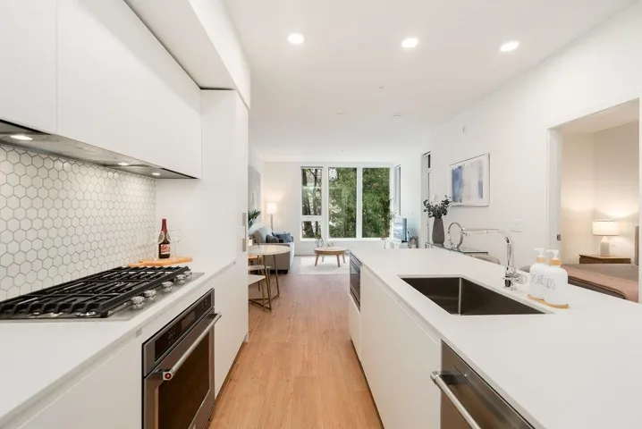 Kitchen with open floor plan, backsplash, white cabinetry, stainless steel appliances, and recessed lighting