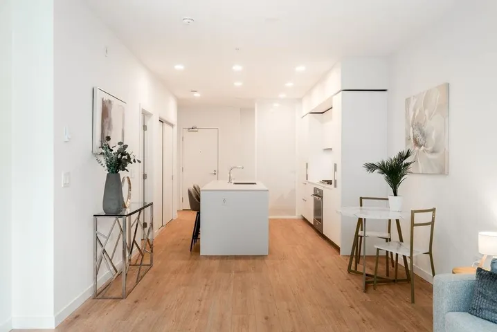 Kitchen featuring white cabinets, modern cabinets, light wood finished floors, a kitchen island with sink, and recessed lighting