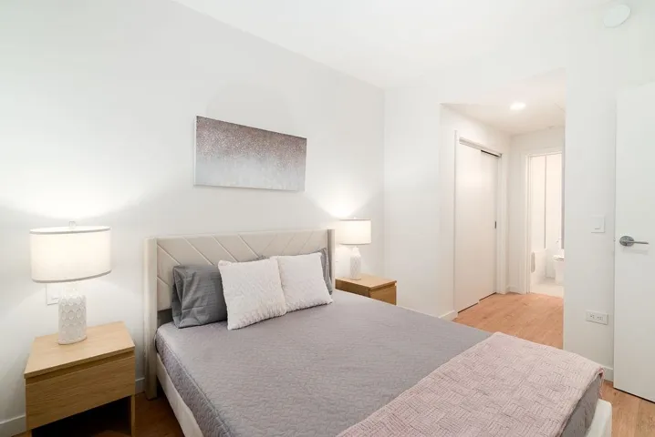 Bedroom with light wood-style flooring, a closet, and ensuite bath