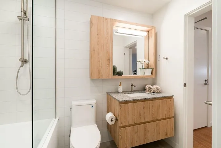 Bathroom featuring vanity, tile walls, and washtub / shower combination