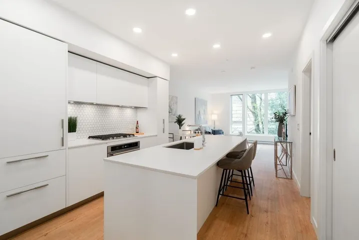 Kitchen with white cabinets, a kitchen island with sink, modern cabinets, tasteful backsplash, and recessed lighting