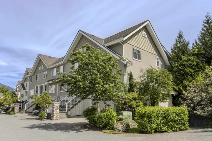 Multi-level townhouse exterior featuring gabled roofs and neutral-toned siding