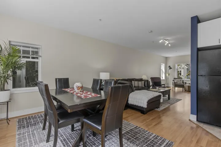 Open-concept living area with wood-finish flooring, recessed lighting, and track lighting