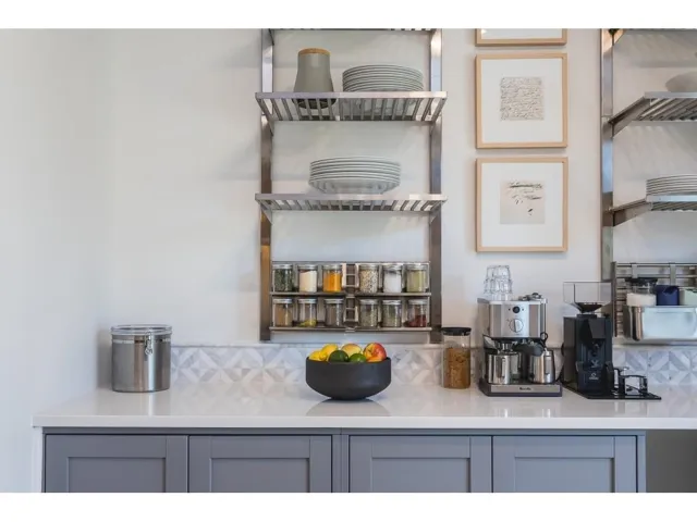 Bar area with tasteful backsplash, gray cabinets, and light stone counters