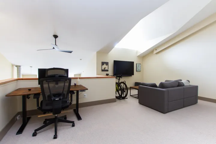 Office area featuring light carpet and baseboards