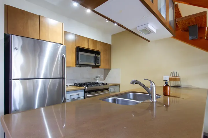 Kitchen featuring a sink, brown cabinets, backsplash, and appliances with stainless steel finishes