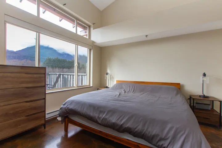 Bedroom with baseboard heating and finished concrete floors