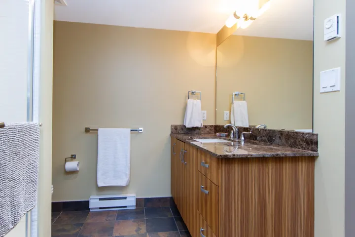 Bathroom featuring vanity, stone finish flooring, baseboards, and a baseboard radiator