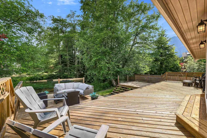Expansive wood deck featuring a tiered design, wood-plank construction, and protective wood railing